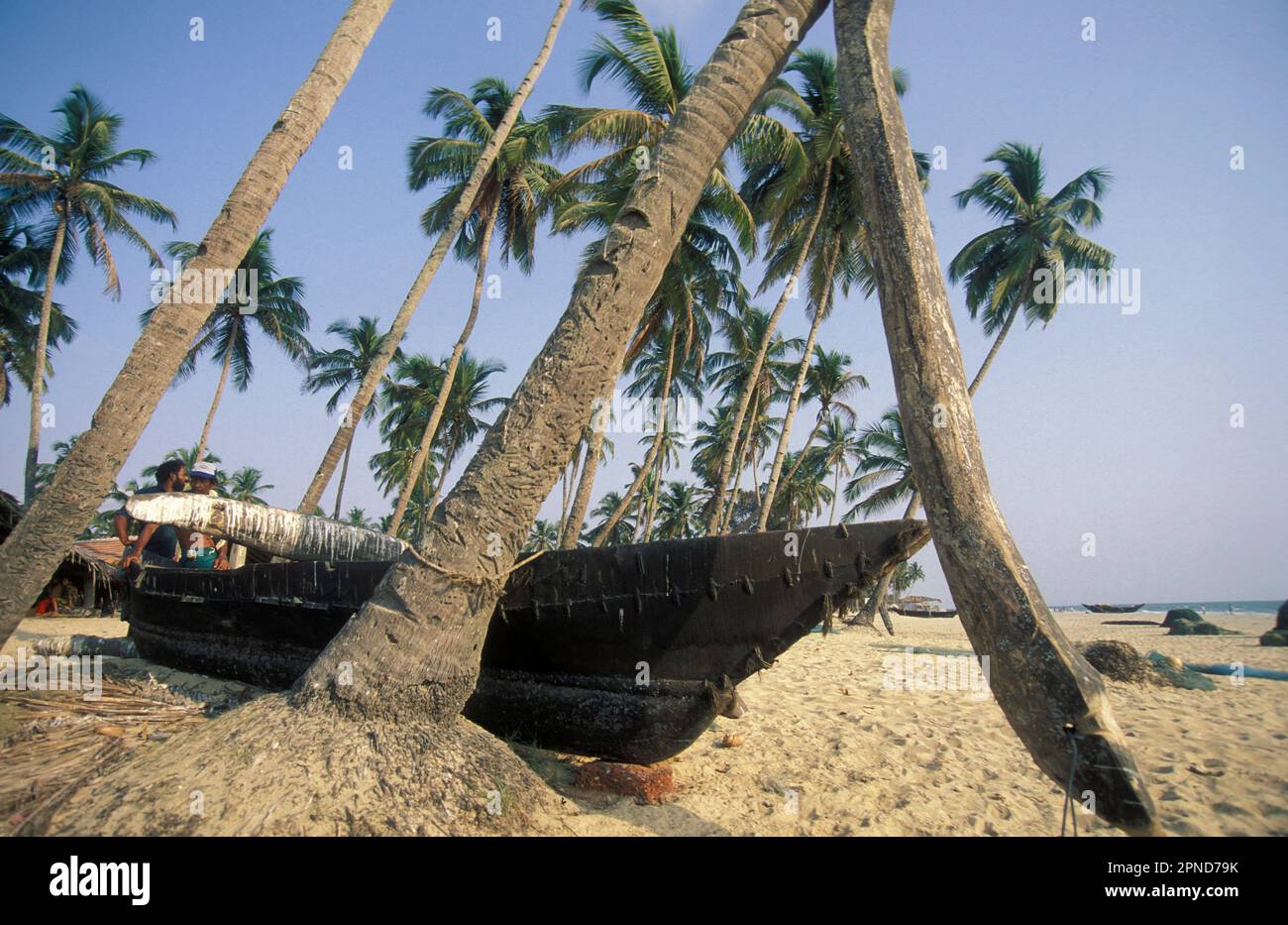 Un pescatore di legno ad una spiaggia sabbiosa con il paesaggio e la costa alla città di Vagator nella provincia di Goa in India, India, Goa, aprile, 1996 Foto Stock