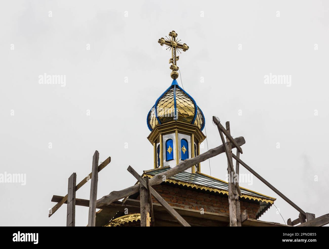 costruzione di un campanile e di una chiesa. Muro di mattoni. Ponteggi in legno Foto Stock
