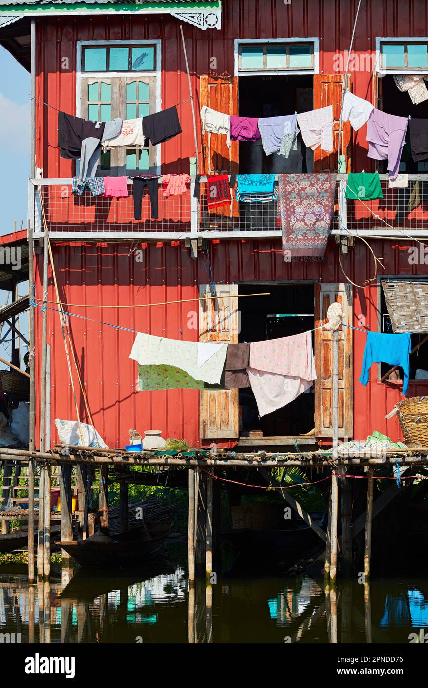 Una variopinta palafitte (palafitte o palafitte) con abiti appesi ad asciugare sul Lago Inle, Stato di Shan, Myanmar. Foto Stock