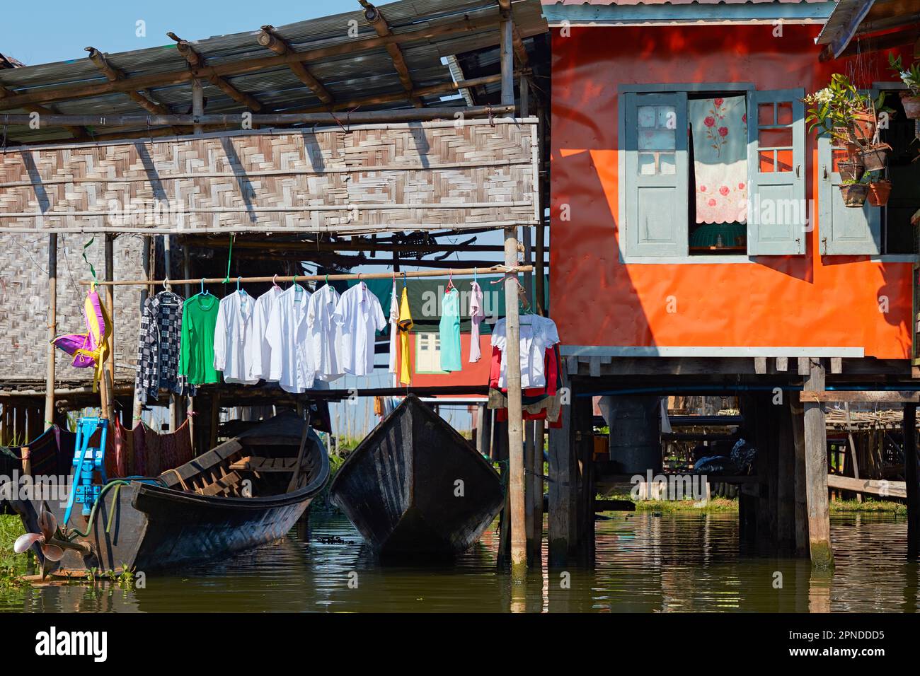 Una variopinta palafitte (palafitte o palafitte) con abiti appesi ad asciugare sul Lago Inle, Stato di Shan, Myanmar. Foto Stock