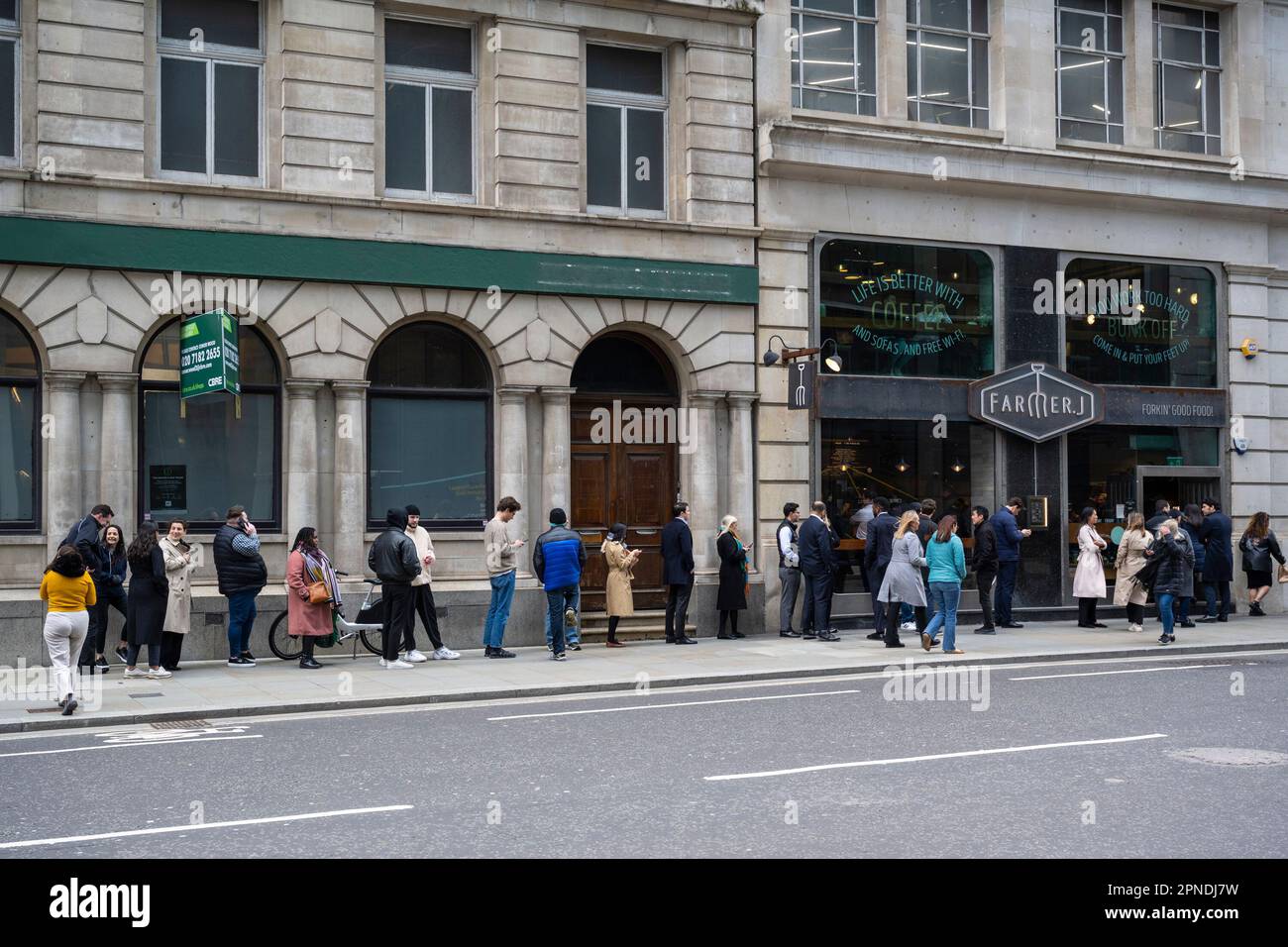 Londra, Regno Unito. 18 aprile 2023. I lavoratori della città si accodano per il pranzo in un ristorante della città di Londra. L'Ufficio per le statistiche nazionali (ONS) ha riferito che i guadagni medi, esclusi i bonus, sono aumentati del 6,6% nei tre mesi fino a febbraio rispetto a un anno fa. Gli economisti hanno commentato che la Banca d’Inghilterra potrebbe alzare i tassi di interesse dall’attuale livello del 4,25% quando la sua commissione per la politica monetaria si riunirà il prossimo 11 maggio per combattere l’inflazione. Credit: Stephen Chung / Alamy Live News Foto Stock