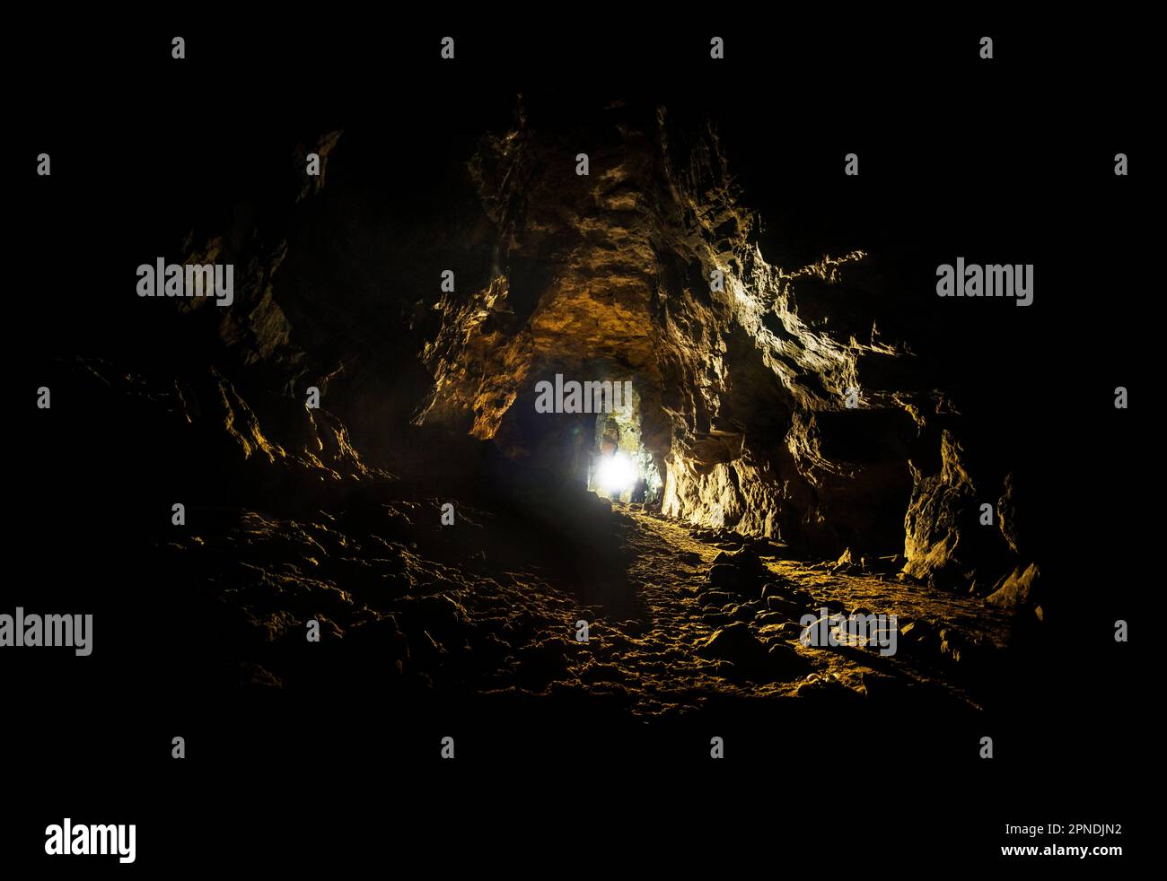 In una miniera di rame sotto Alderley Edge a Cheshire, le persone con torce speleologia ed esplorare lo spazio sotterraneo della miniera ovest profondo sotto il terreno Foto Stock