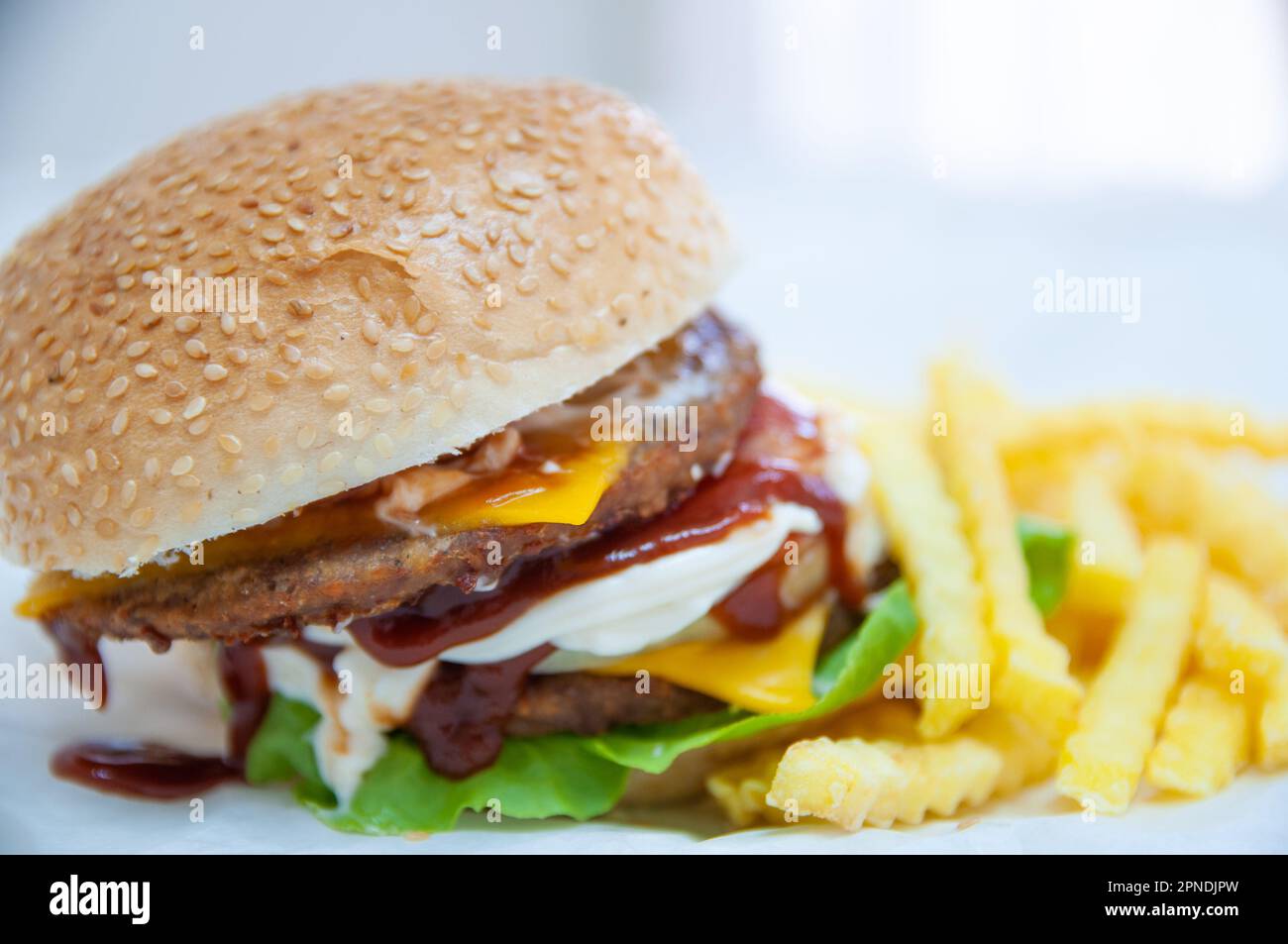 Doppio Cheeseburger servito con patate fritte Foto Stock