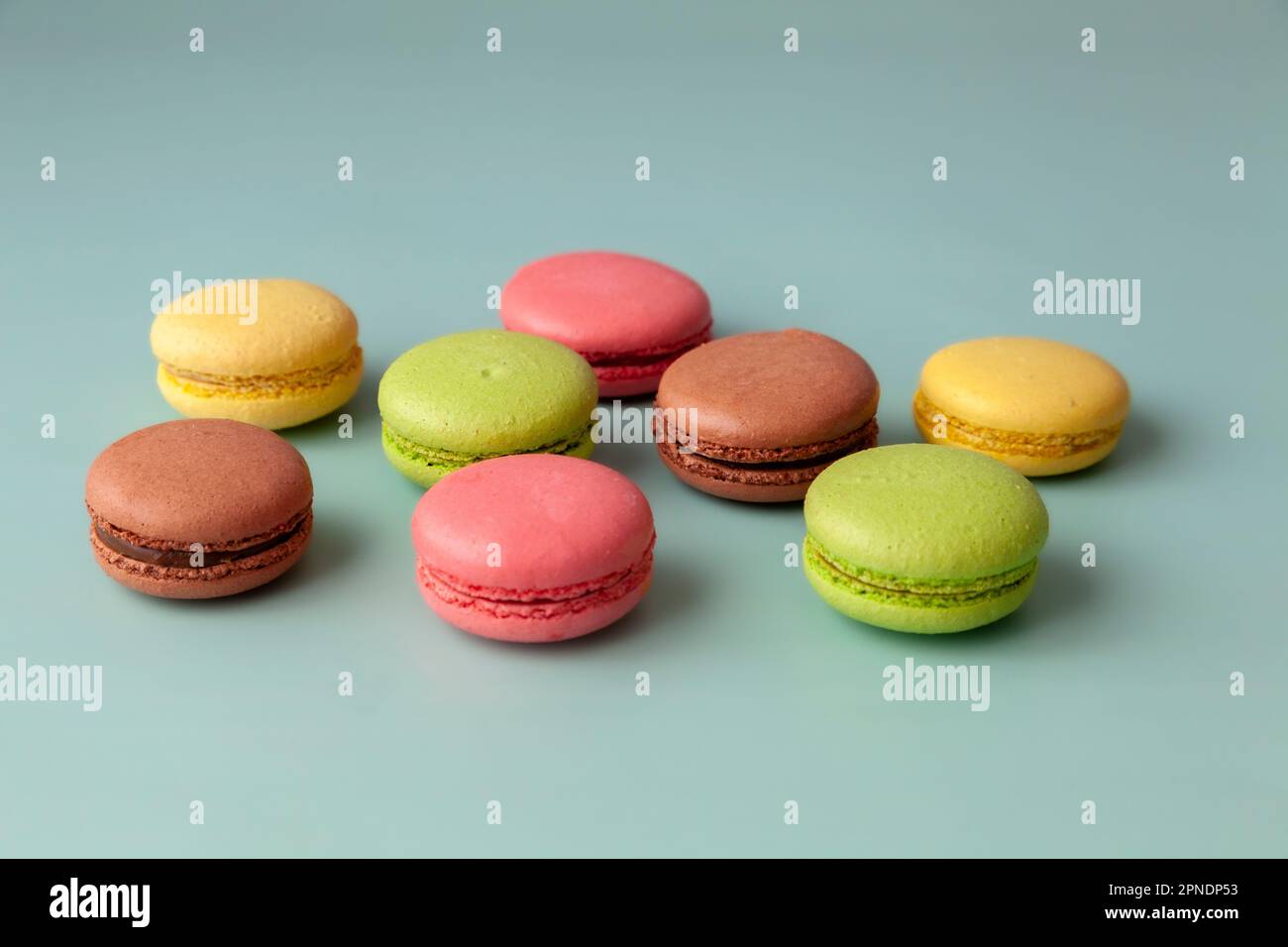 Macaron multicolore su fondo turchese primo piano Foto Stock