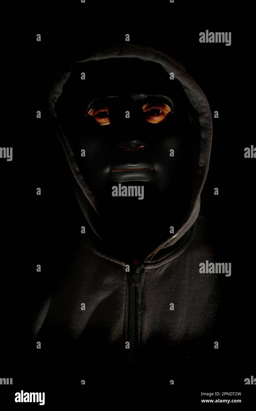 uomo misterioso con maschera e cappuccio neri Foto Stock