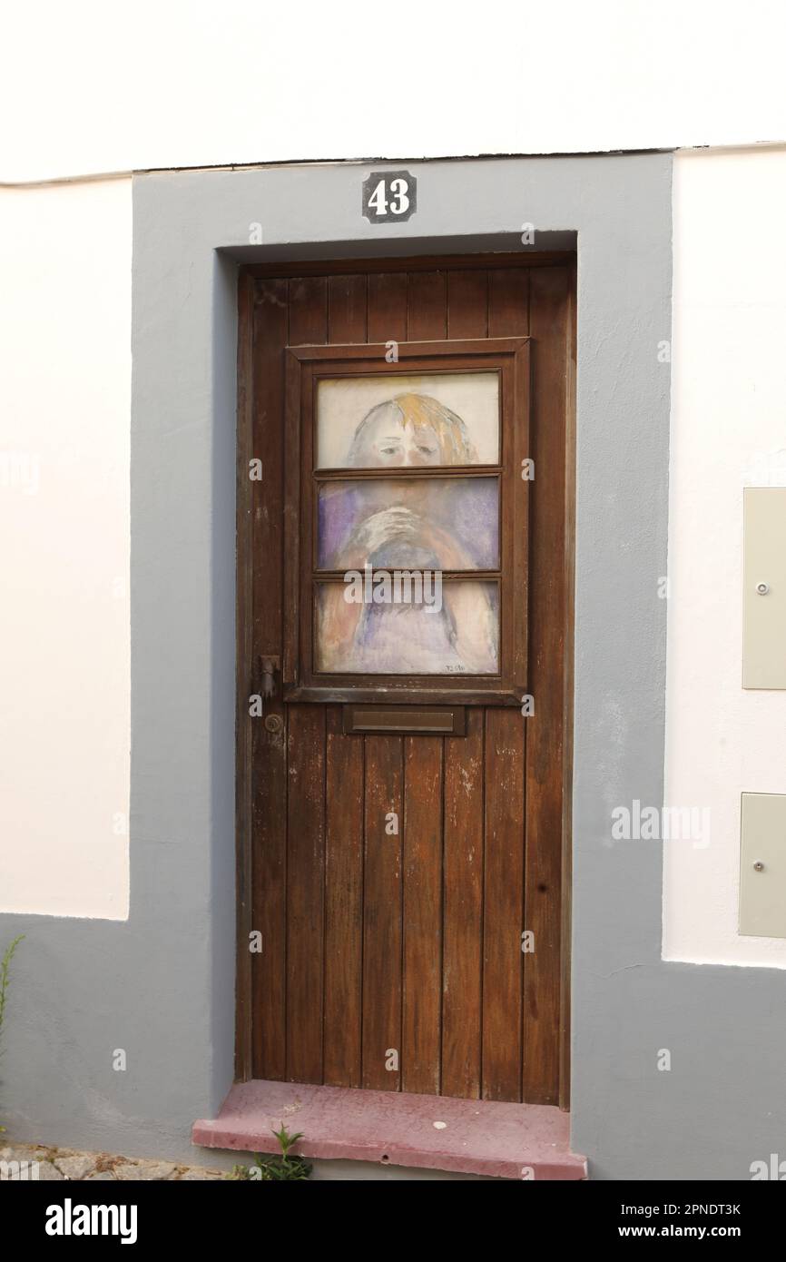 Un dipinto di una donna in una porta, Città Vecchia, Lagos, Algarve, Portogallo Foto Stock