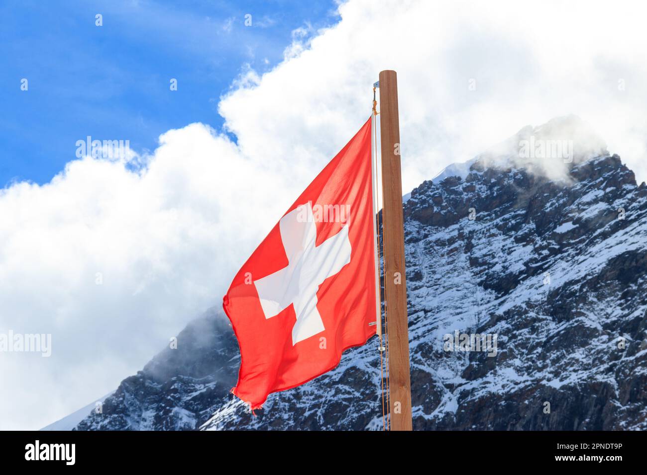 Bandiera svizzera rossa sullo sfondo delle Alpi svizzere Foto Stock