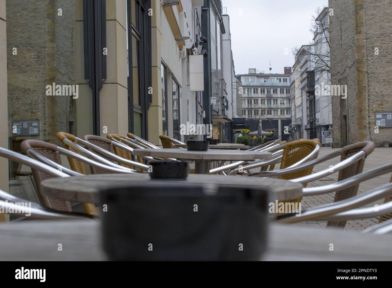 Tavoli vuoti nel vicolo ciottolato di Bielefeld. Foto Stock