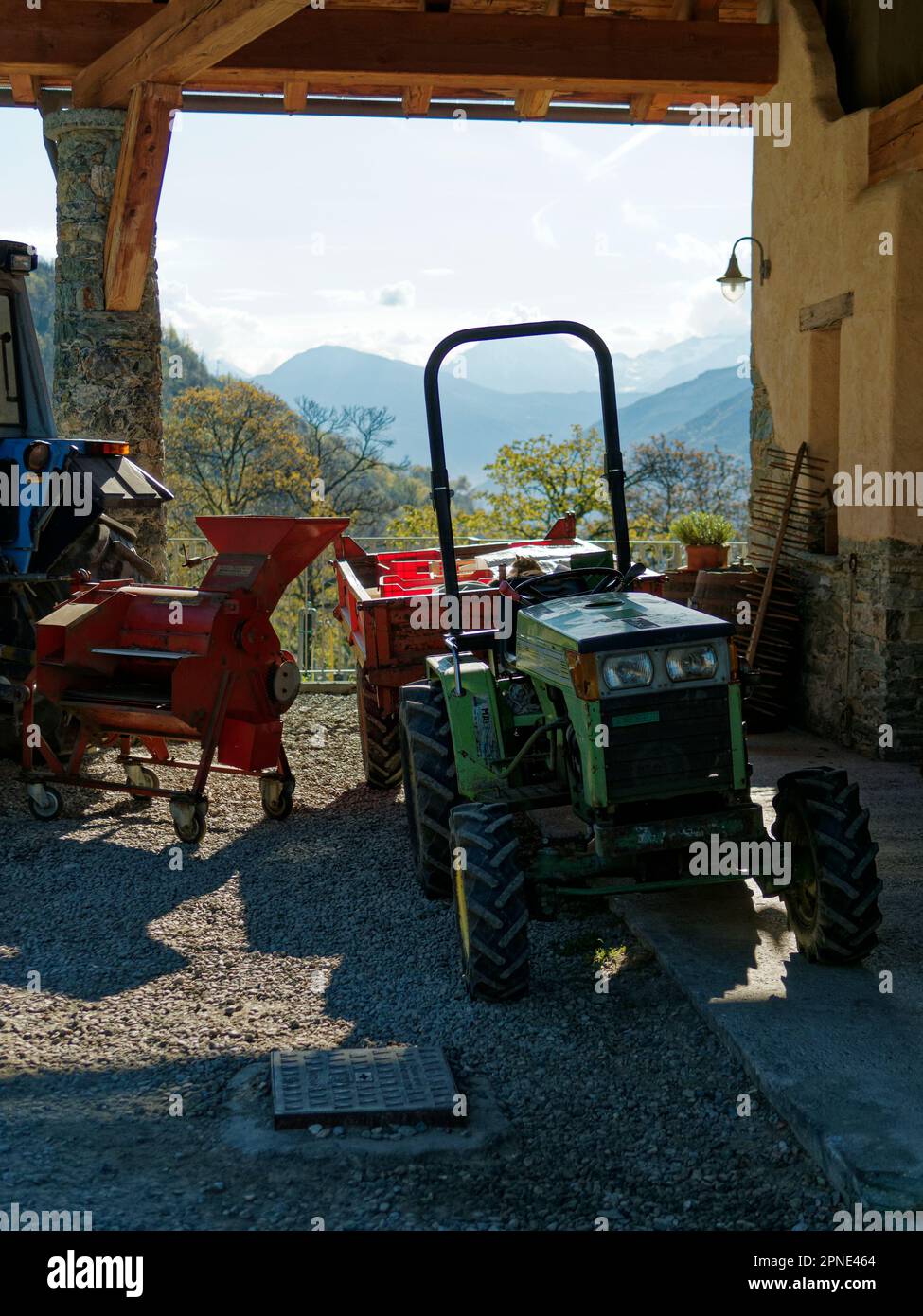 Piccolo trattore Ferrari verde con una macchina arancione collegata a un altro trattore Foto Stock