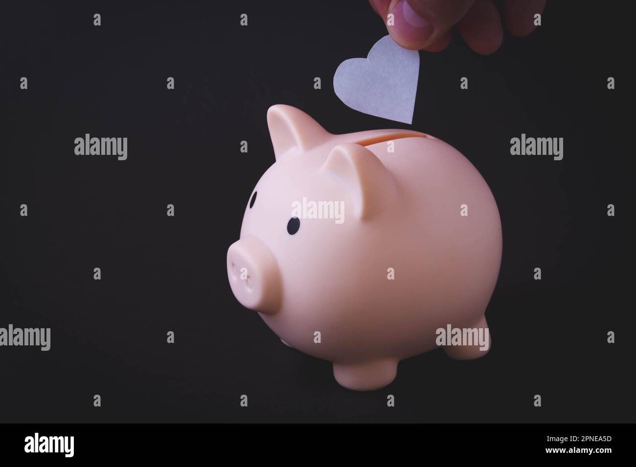 Maiale banca e accumulazione di fondi. Cuore in una banca di piggy. Il concetto di sicurezza. Foto Stock