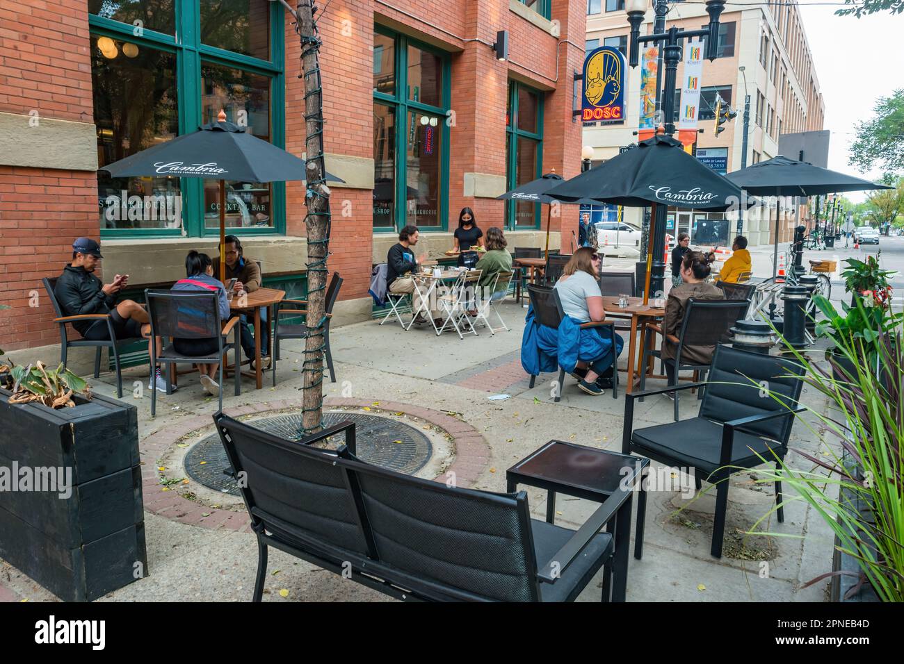 La gente si siede su un patio ristorante sull'elegante 4th Street Promenade nel centro di Edmonton Alberta Canada Foto Stock