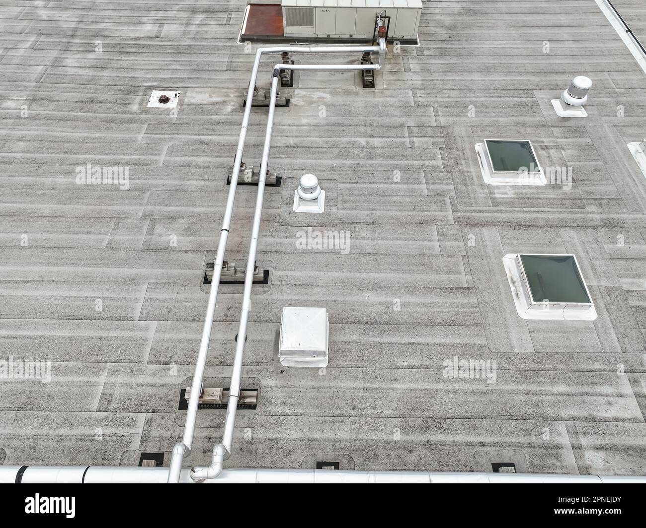 Vista aerea di un impianto HVAC dall'aspetto industriale e di tubi sul tetto grigio. Foto Stock