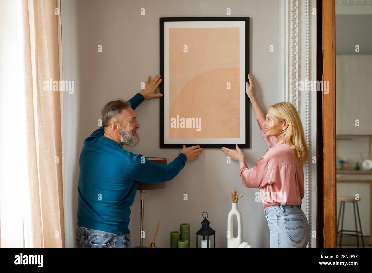 Felice coppia appeso immagine in cornice al muro al coperto Foto Stock