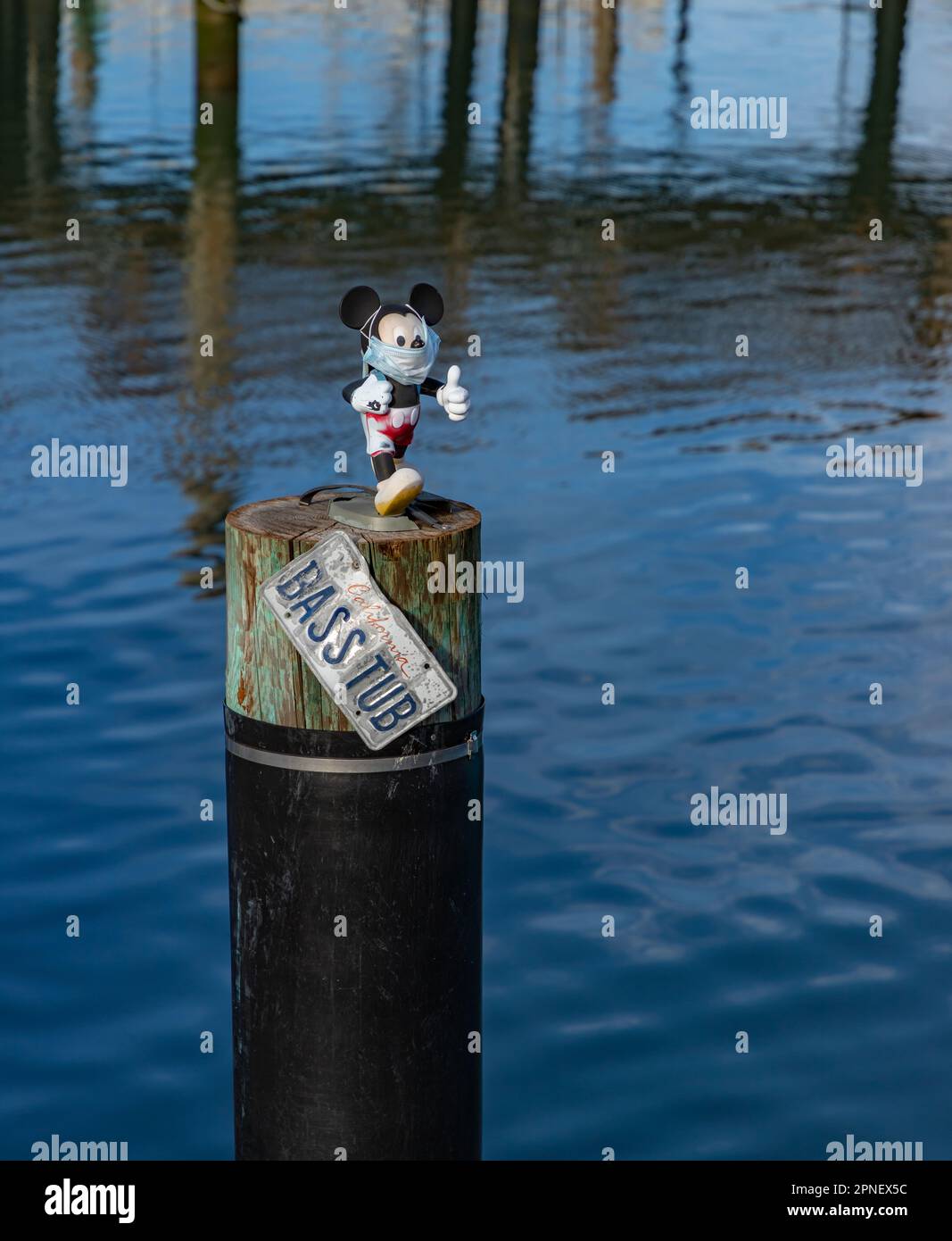 Una foto di una piccola bambola mascherata Topolino seduta in cima a una colonna sul lungomare di San Francisco. Foto Stock