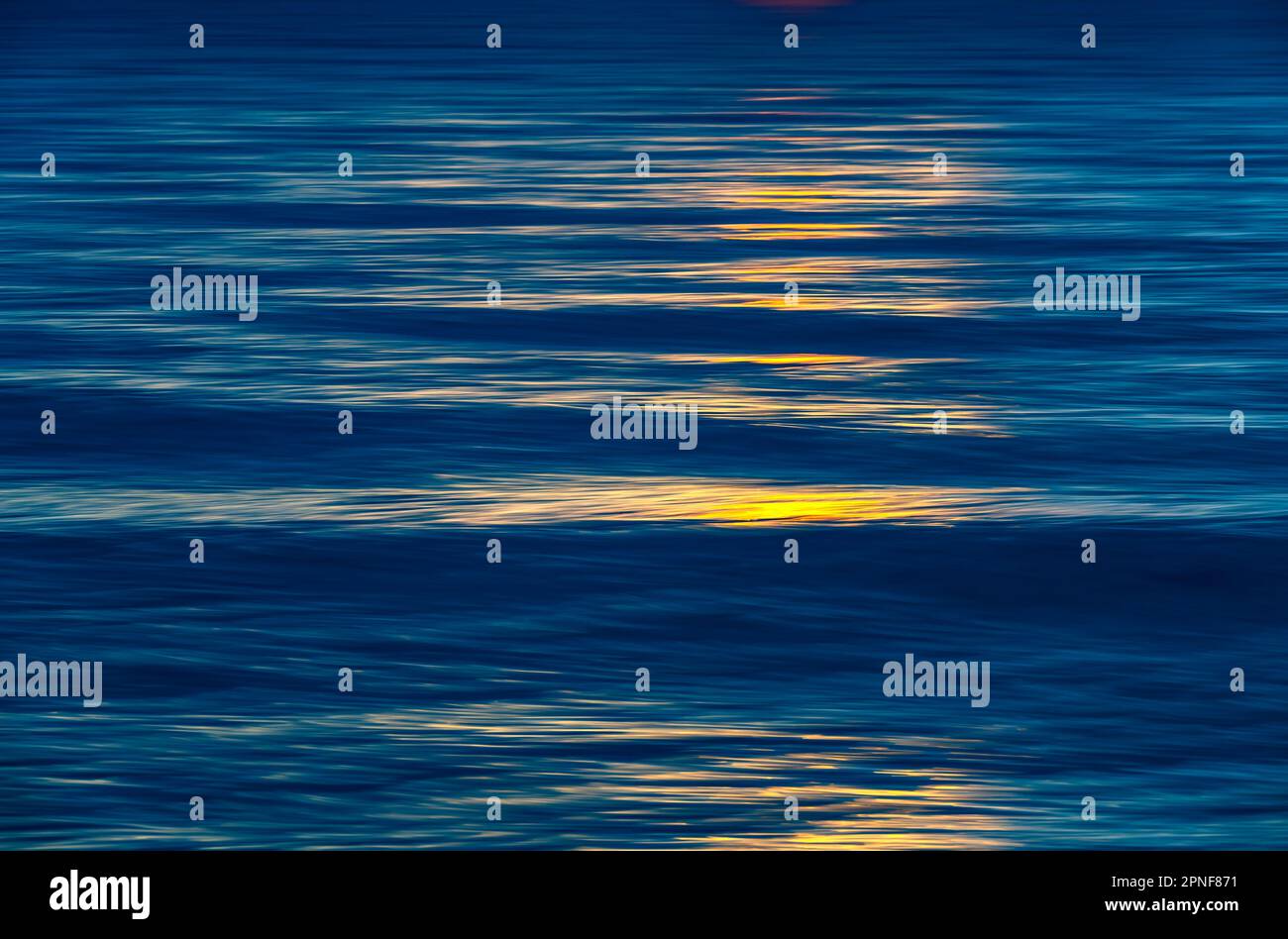 Luce solare riflessa in una superficie d'acqua calma Foto Stock
