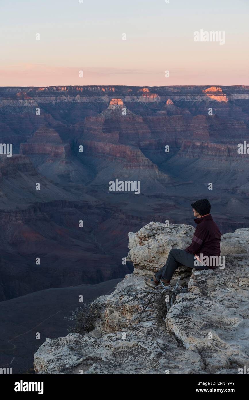 Stati Uniti, Arizona, Grand Canyon National Park, South Rim, escursionista senior seduto al bordo del Grand Canyon e guardando la vista Foto Stock
