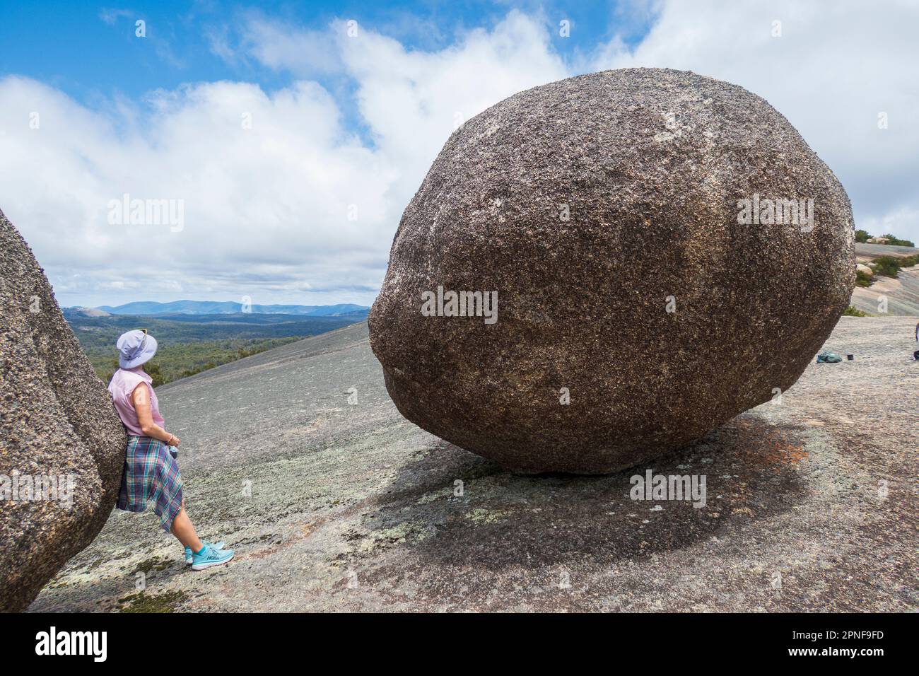 Australia, nuovo Galles del Sud, Parco Nazionale di Bald Rock, Donna in piedi accanto al grande masso Foto Stock