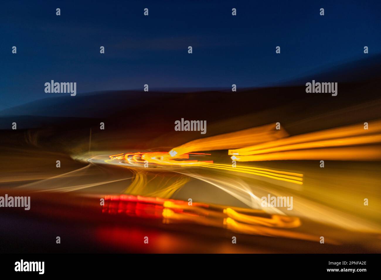 Immagine sfocata delle luci sull'autostrada al tramonto Foto Stock