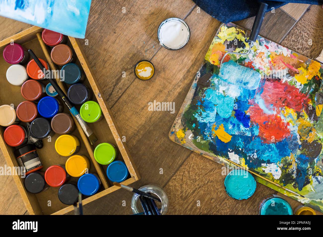 Vista ad alto angolo di pennelli, pallete, oli, acrilici e altri elementi di un pittore. Laboratorio d'arte. Sfondo. Foto Stock