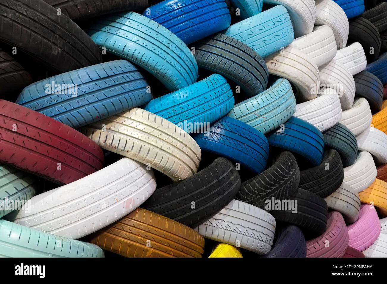 Parete di colorati pneumatici riciclati Foto Stock