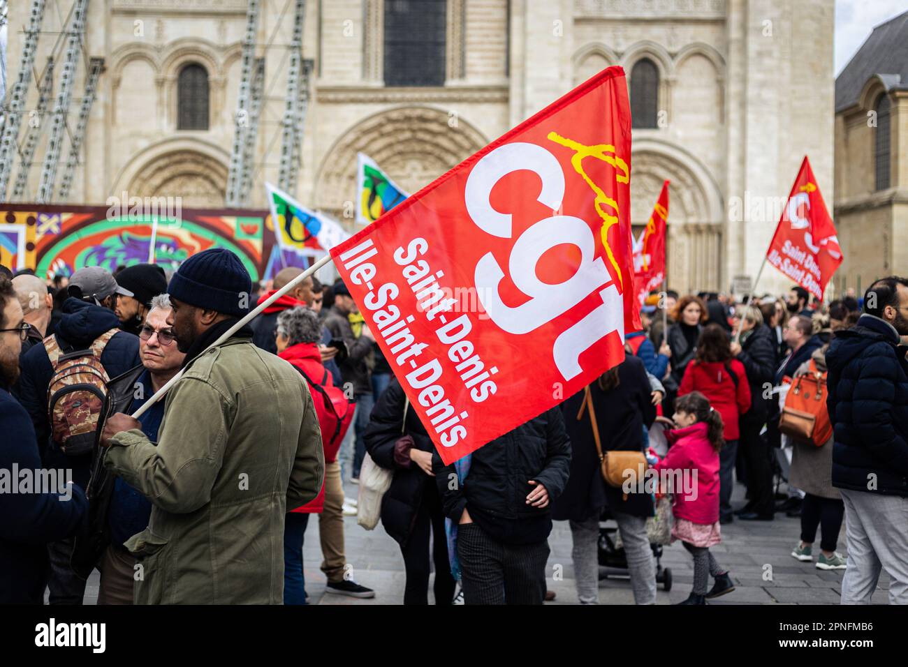 Parigi, Francia. 18th Apr, 2023. Un protester è visto tenendo una bandiera di Saint-Denis CGT (Confédération Générale du Travail) durante la manifestazione. Più di 300 persone si sono riunite questa sera a Saint-Denis, Parigi, dove Emmanuel Macron doveva assistere a un concerto presso la casa di formazione Legion of Honor. La protesta si è svolta in una piazza affollata del municipio, vicino alla Basilica di Saint-Denis, in cui si è rinata la motocicletta presidenziale. Credit: SOPA Images Limited/Alamy Live News Foto Stock