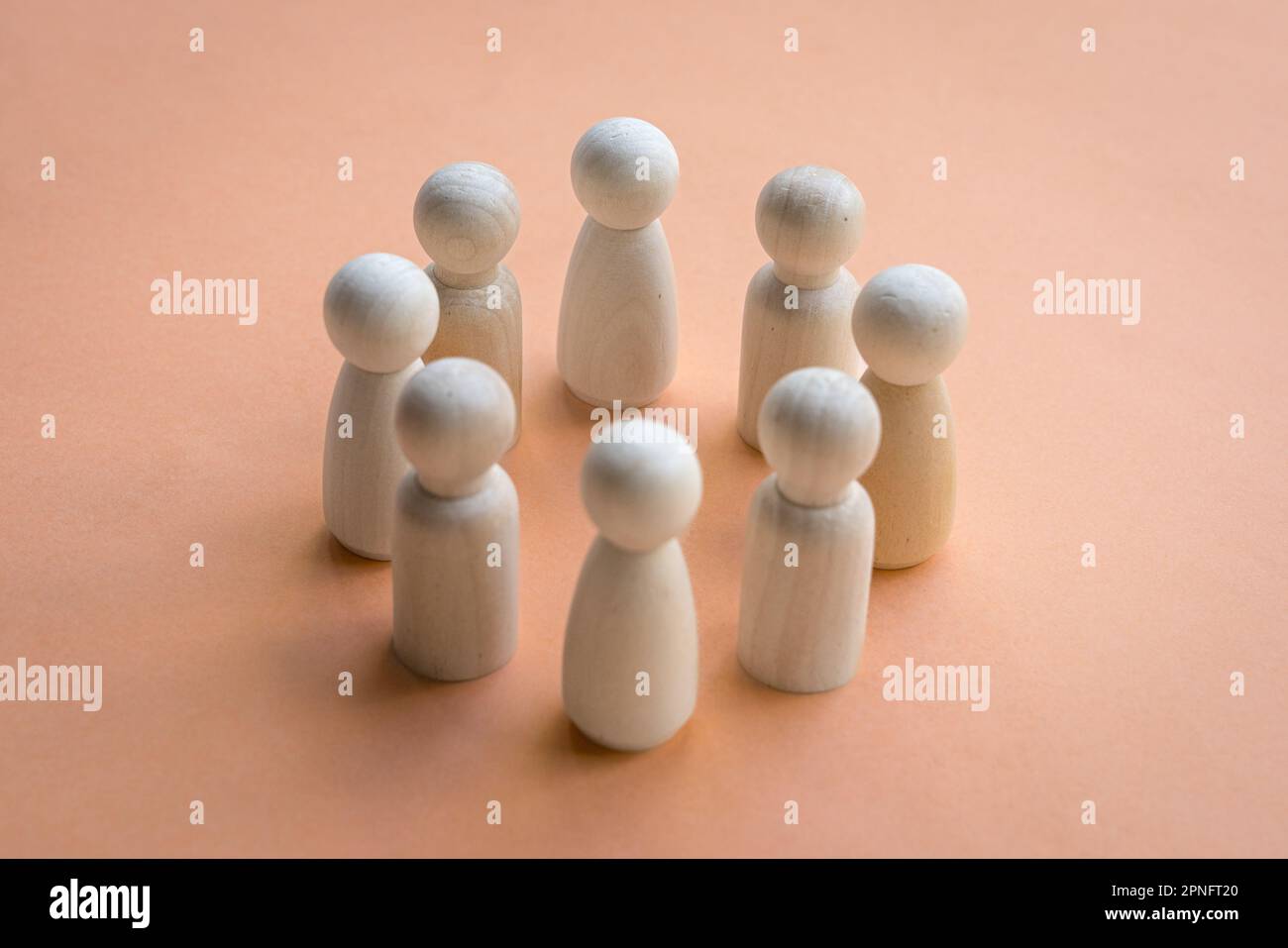 Bambole di legno in piedi in un cerchio di fronte l'una all'altra. Decisione del team o concetto di collaborazione. Foto Stock