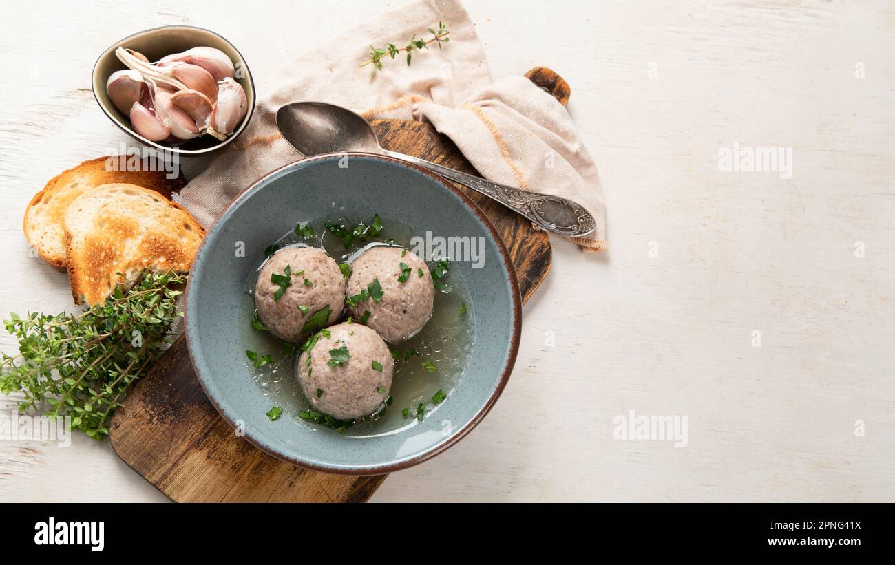 Canederli o Knodel in brodo con cipolla verde, pasta tipica o gnocchi per le Alpi, Alto Adige, cucina tedesca, italiana, austriaca. In bre obsoleto Foto Stock