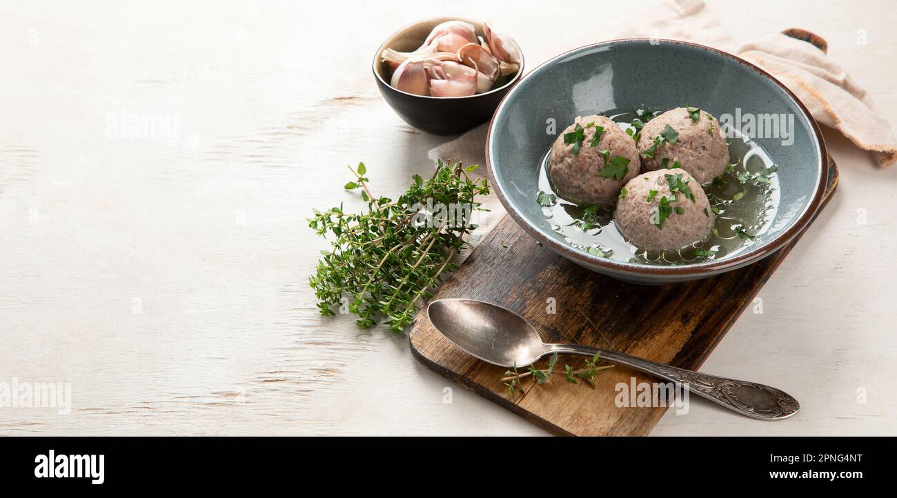 Canederli o Knodel in brodo con cipolla verde, pasta tipica o gnocchi per le Alpi, Alto Adige, cucina tedesca, italiana, austriaca. In bre obsoleto Foto Stock