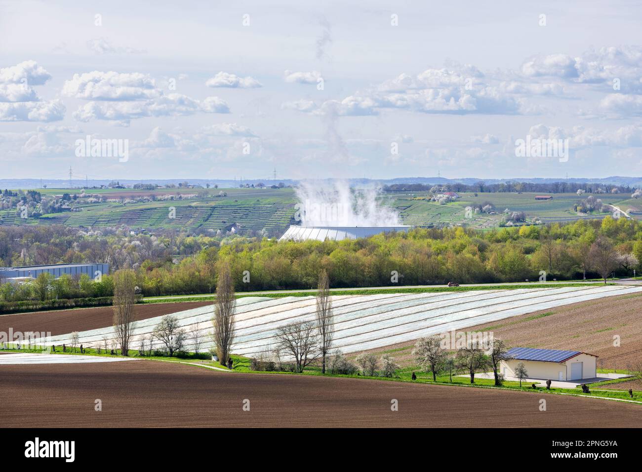 Torre di raffreddamento della centrale nucleare di Neckarwestheim, campi di grano, capannone di attrezzature, Neckarwestheim, Baden-Wuerttemberg, Germania Foto Stock