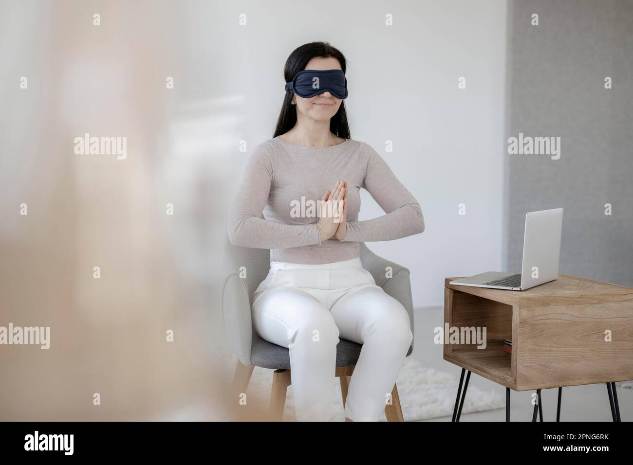 Donna seduta sulla sedia che fa un'esercitazione di rilassamento Foto Stock