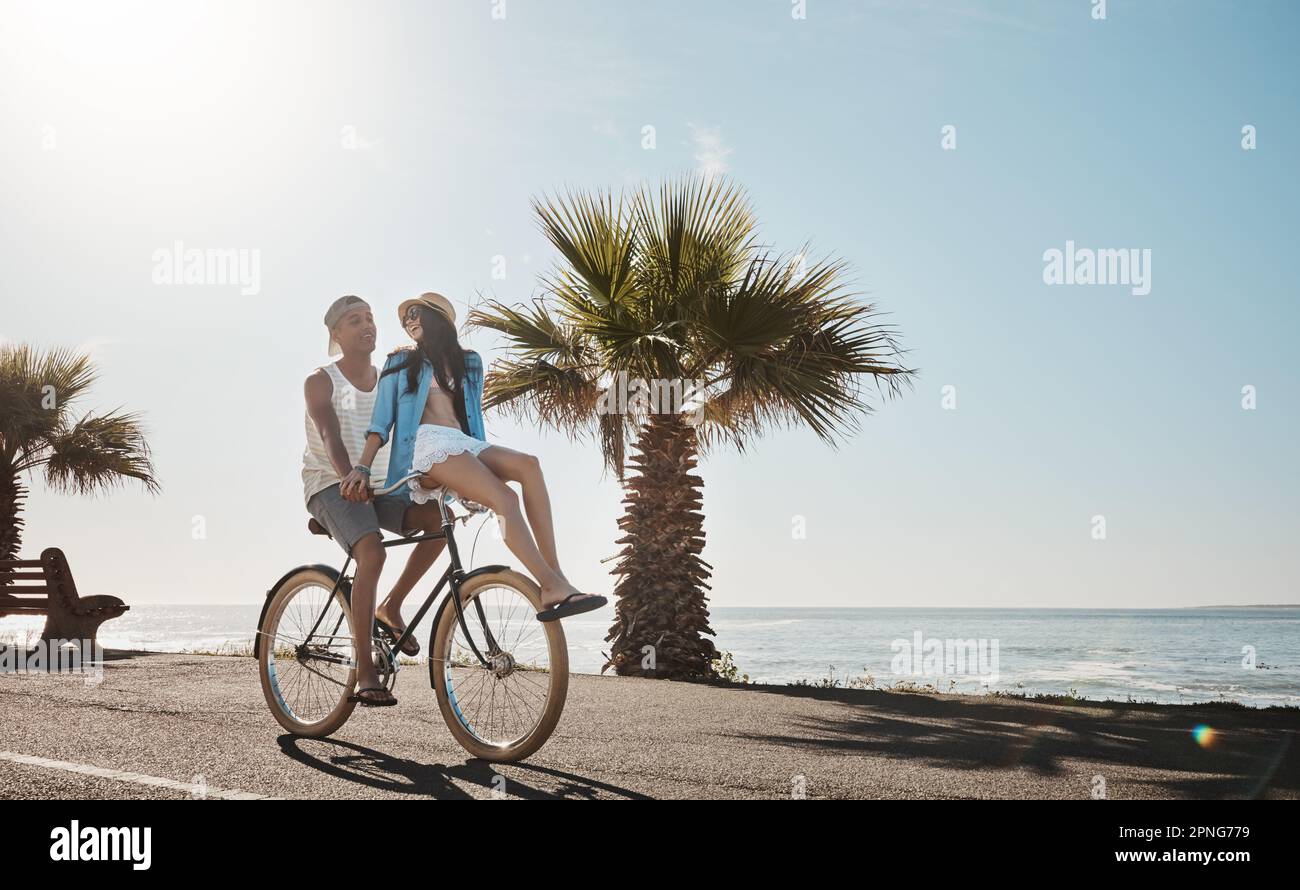 Viaggio lungo un sentiero pieno di sole. una giovane coppia in bicicletta insieme sul lungomare. Foto Stock