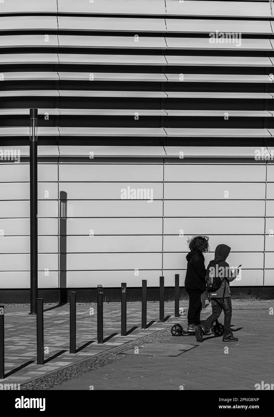 Fotografia in bianco e nero, camminatore di fronte all'architettura moderna, Friedrichshain, Berlino, Germania Foto Stock