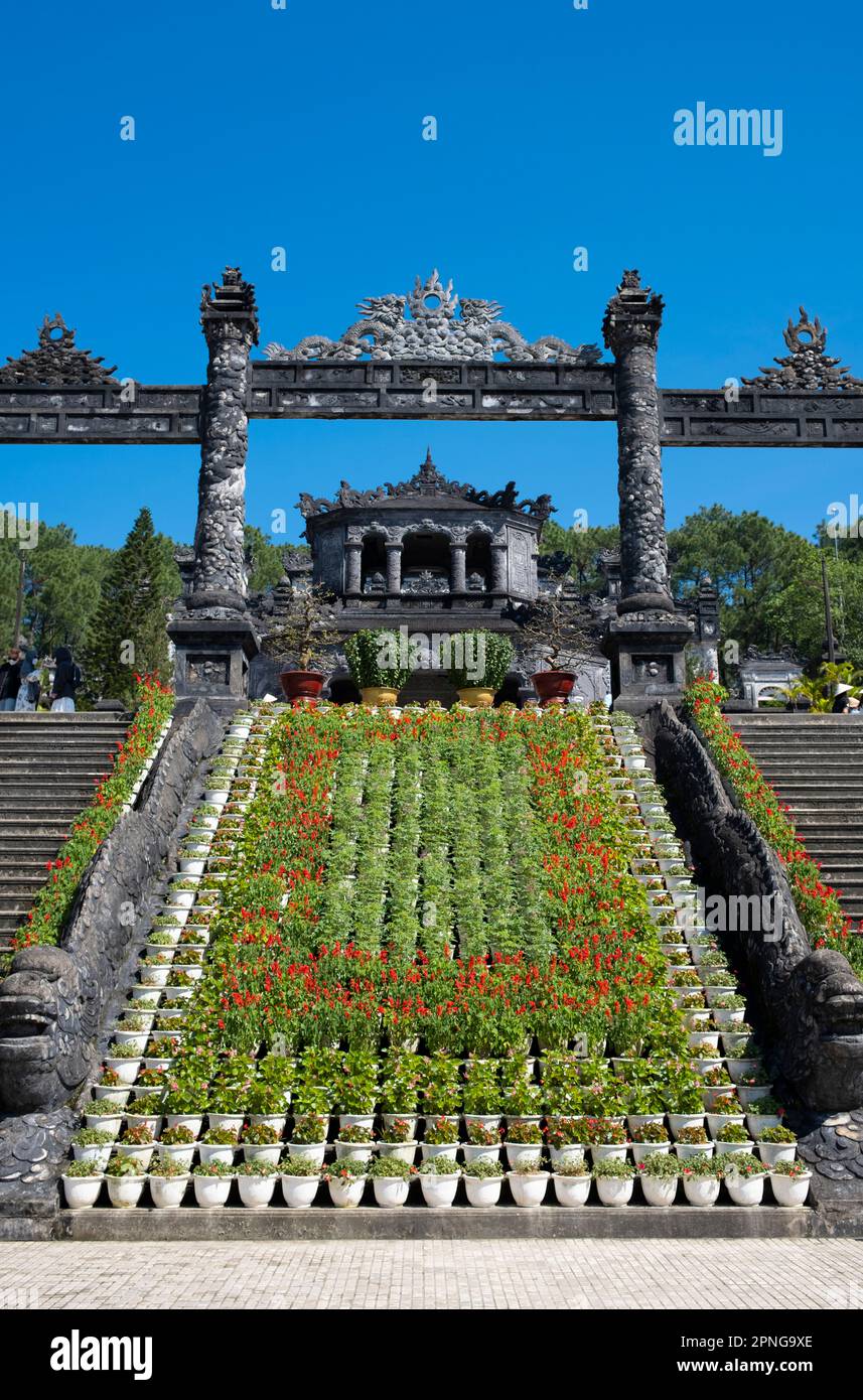 Vietnam: Fiori decorare la scala che conduce alla tomba dell'imperatore Khai Dinh, Hue. Imperatore Khải Định (8 ottobre 1885 – 6 novembre 1925) è stato il 12th imperatore della dinastia Nguyễn in Vietnam. Il suo nome alla nascita era il principe Nguyễn Phúc Bửu Đảo. Era figlio dell'imperatore Đồng Khánh, ma non gli successe subito. Regnò solo nove anni: 1916 - 1925. Hue fu la capitale imperiale della dinastia Nguyen tra il 1802 e il 1945. Le tombe di diversi imperatori si trovano in città e nei dintorni e lungo il fiume dei profumi. Hue è un sito patrimonio dell'umanità dell'UNESCO. Foto Stock