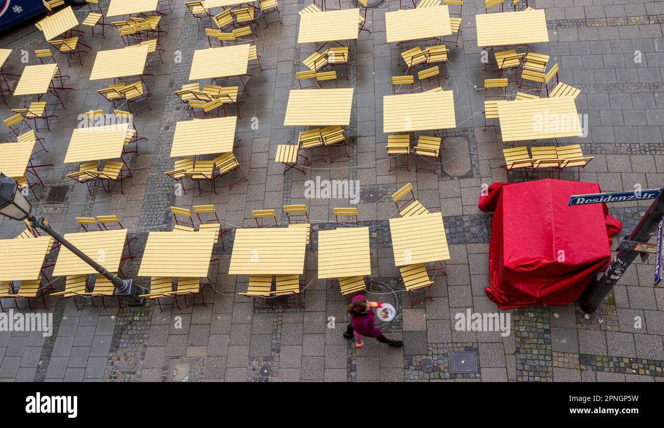 Monaco, Germania. 19th Apr, 2023. Una donna passa davanti a un bar vuoto sul marciapiede. Credit: Peter Kneffel/dpa/Alamy Live News Foto Stock