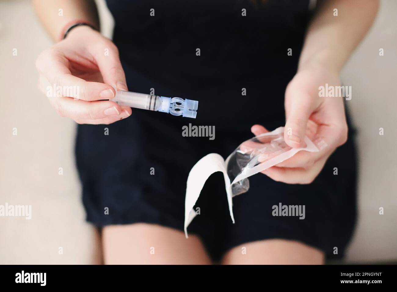 Le mani femminili disimballano un nuovo serbatoio per la pompa per insulina Foto Stock