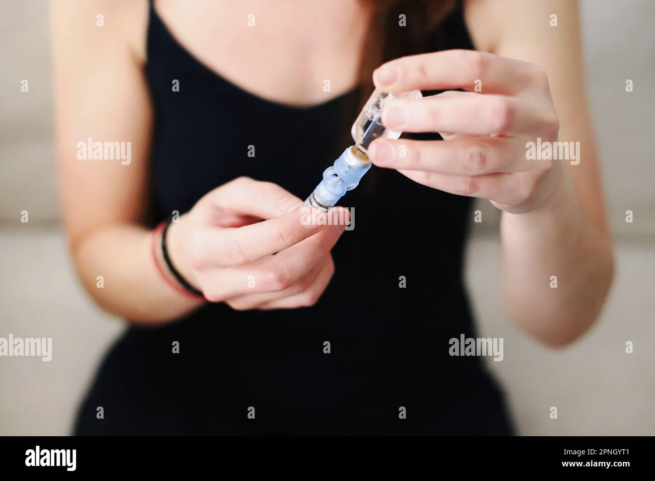 Donna che riempie di insulina il serbatoio della pompa per insulina Foto Stock