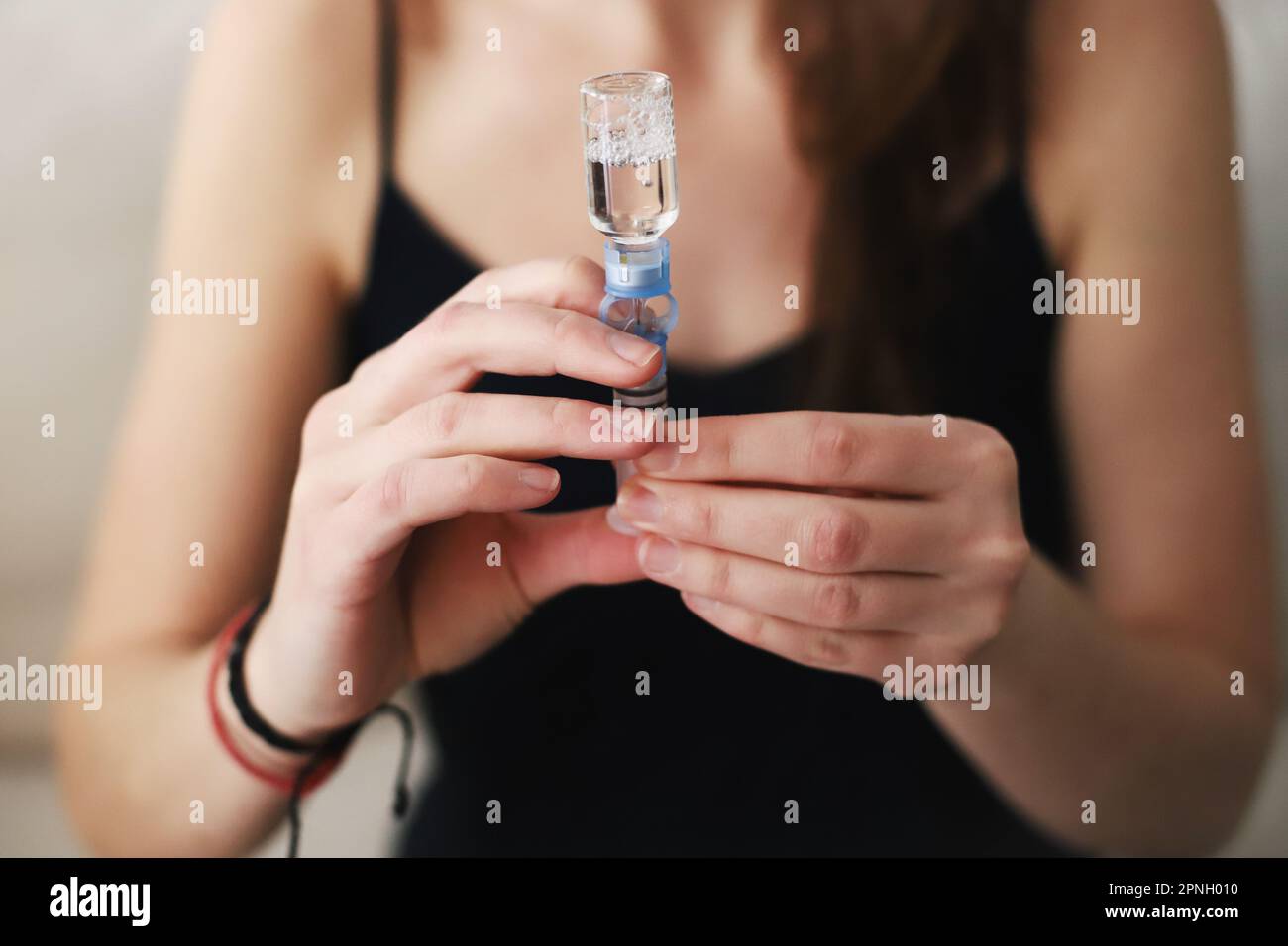 Donna che riempie di insulina il serbatoio della pompa per insulina Foto Stock