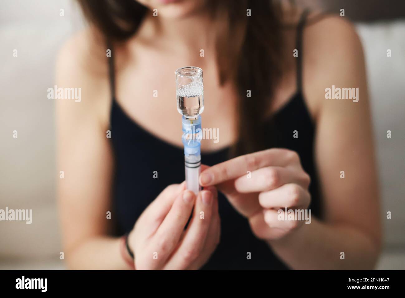 Donna che riempie di insulina il serbatoio della pompa per insulina Foto Stock