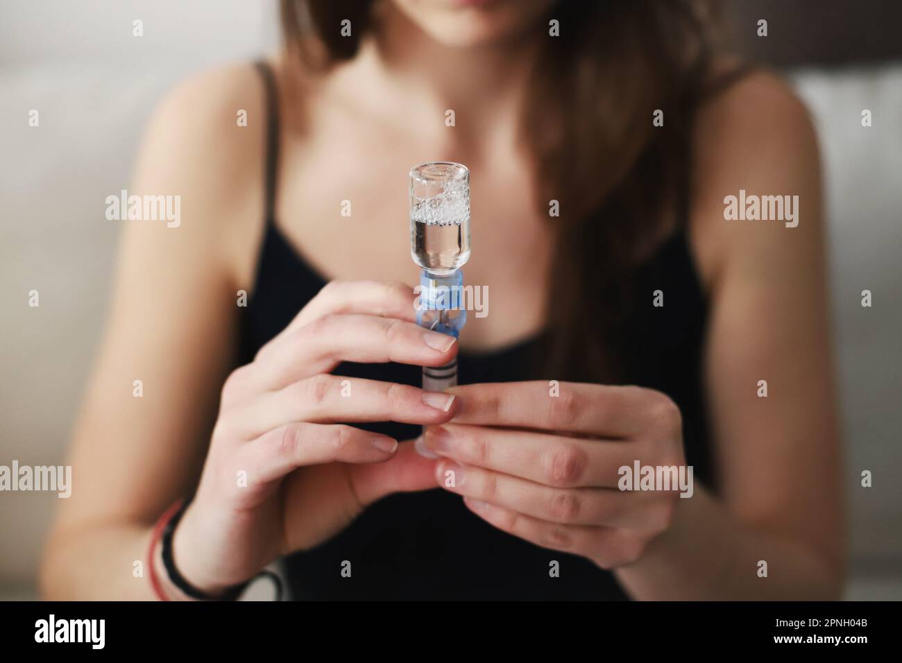 Donna che riempie di insulina il serbatoio della pompa per insulina Foto Stock