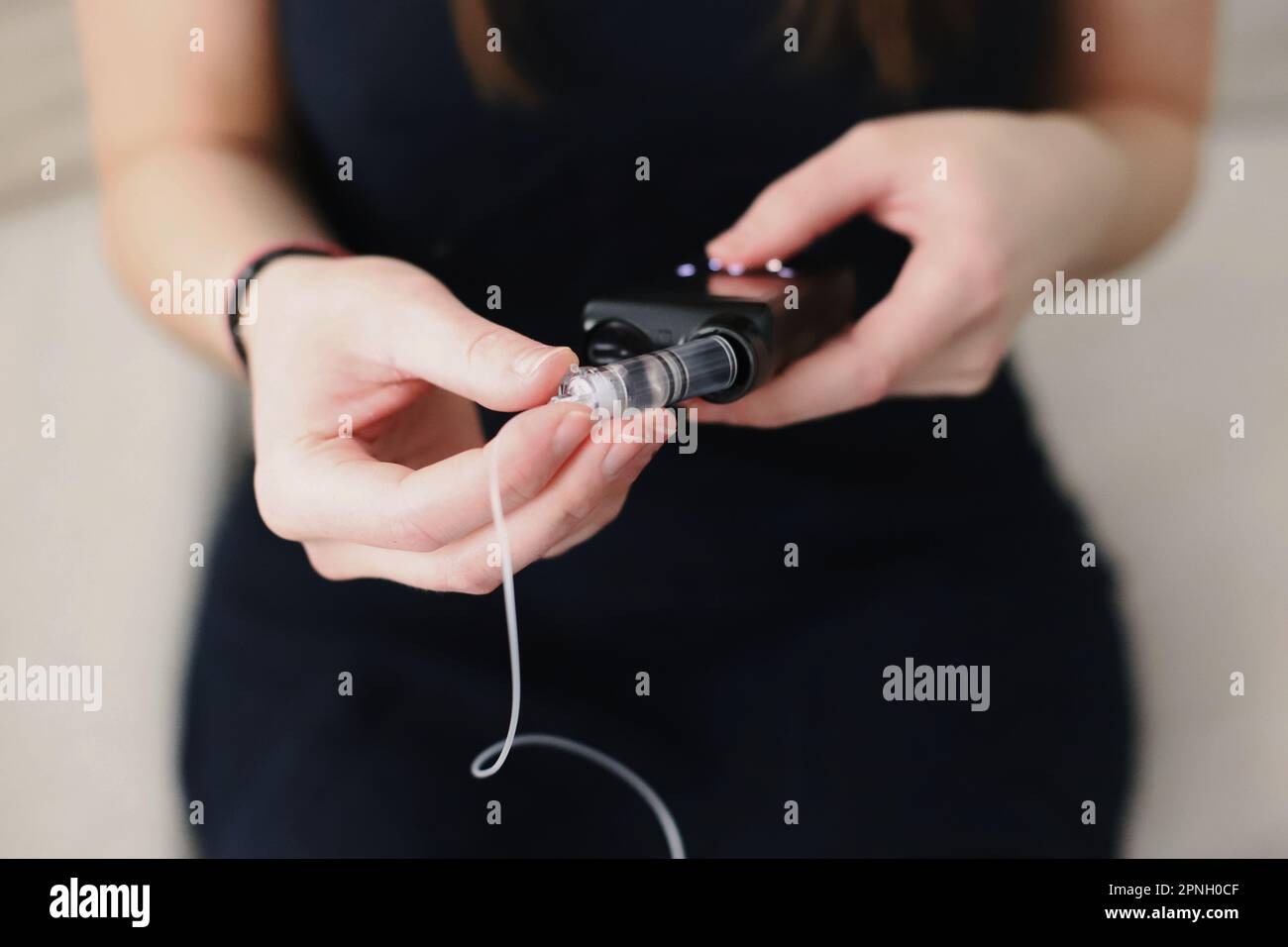 Donna che mette un serbatoio pieno nella sua pompa per insulina Foto Stock