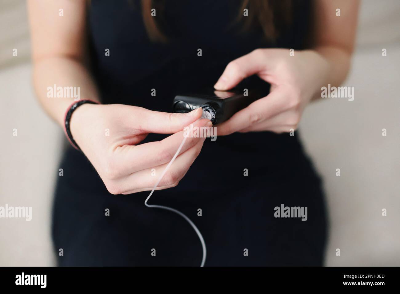 Donna che mette un serbatoio pieno nella sua pompa per insulina Foto Stock