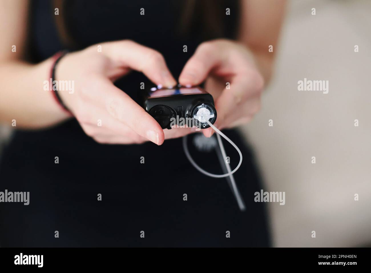 Donna che tiene in mano il suo tiralatte per insulina Foto Stock