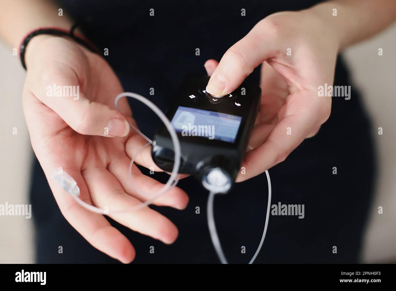 Donna che tiene in mano il suo tiralatte per insulina Foto Stock
