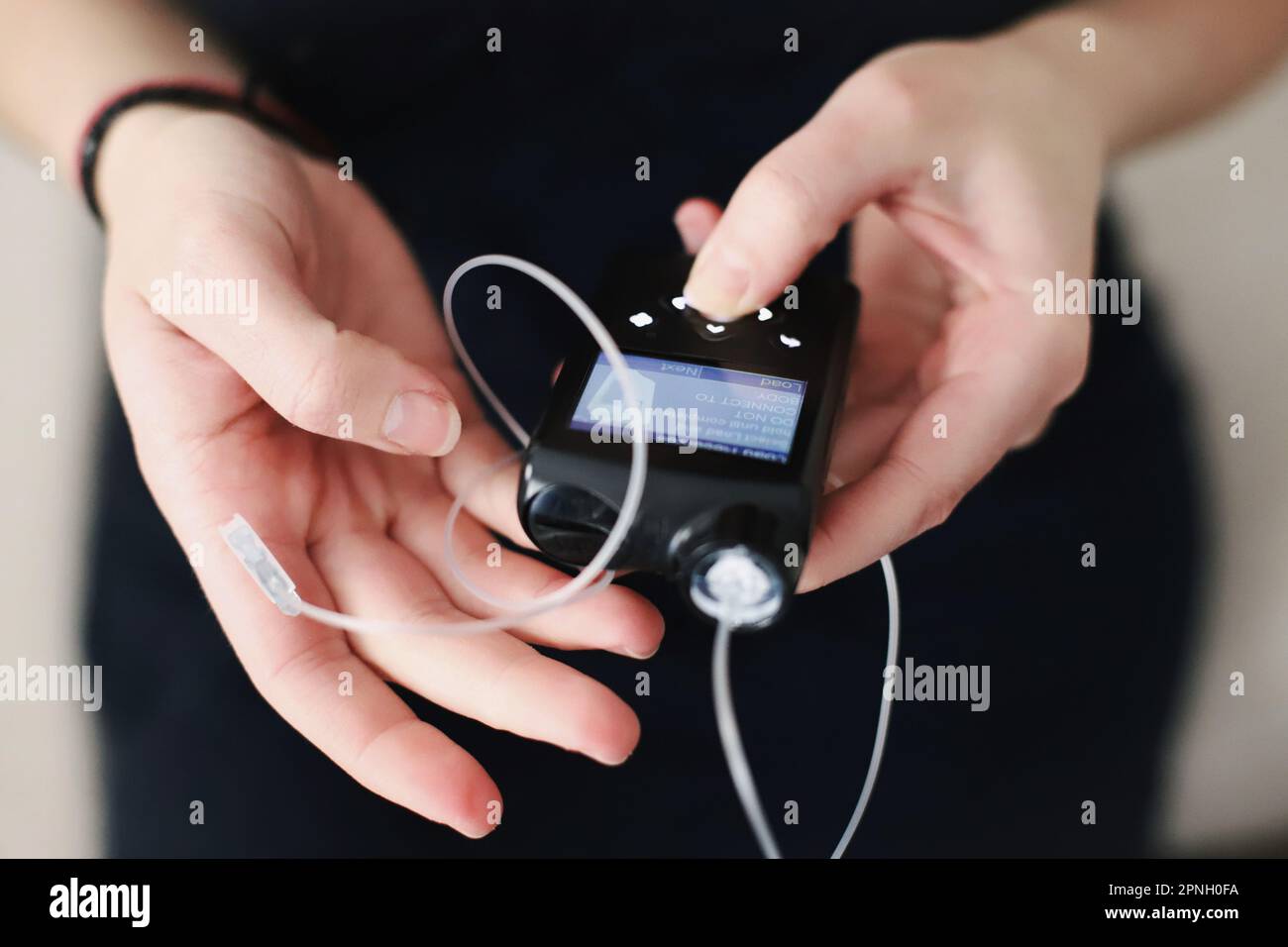 Donna che tiene in mano il suo tiralatte per insulina Foto Stock