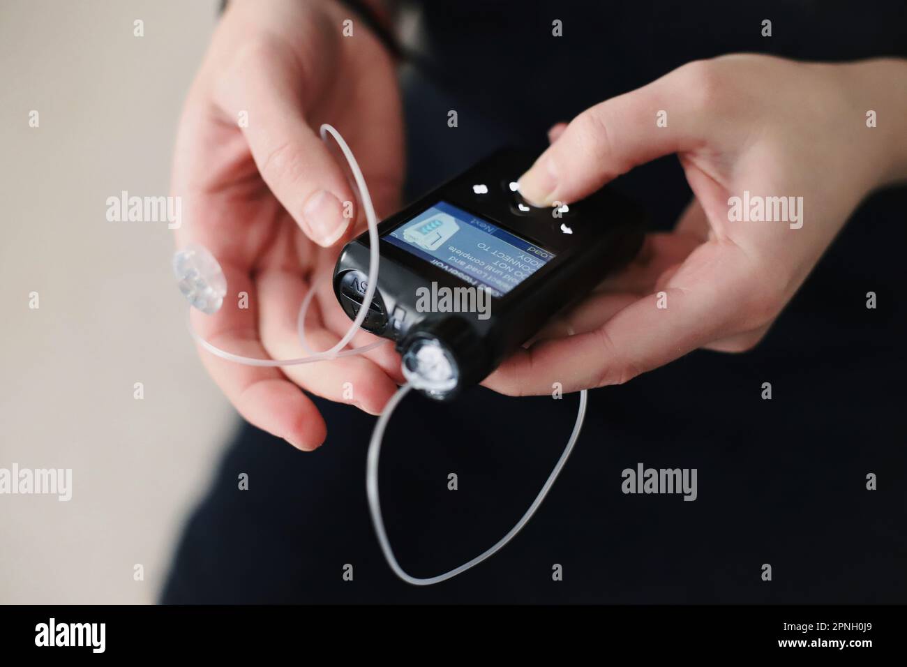 Donna che tiene in mano il suo tiralatte per insulina Foto Stock