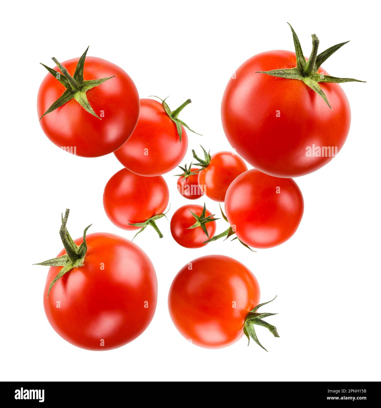 Piccoli pomodori ciliegini rossi galleggianti su sfondo bianco. Foto Stock