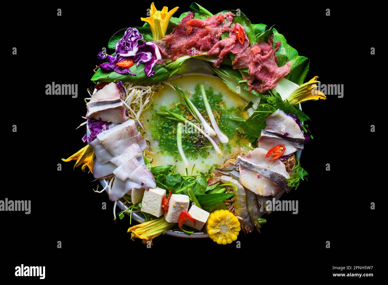 Hot pot coreano con pesce crudo su sfondo nero Foto Stock