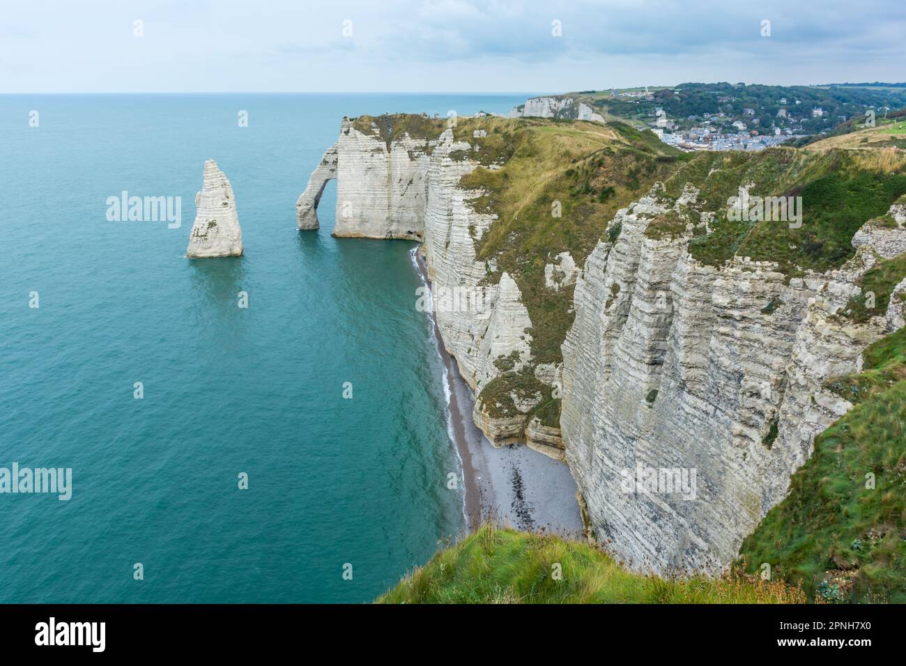 Vista panoramica della costa di Etretat in Normandia Francia con mare calmo contro il cielo drammatico Foto Stock