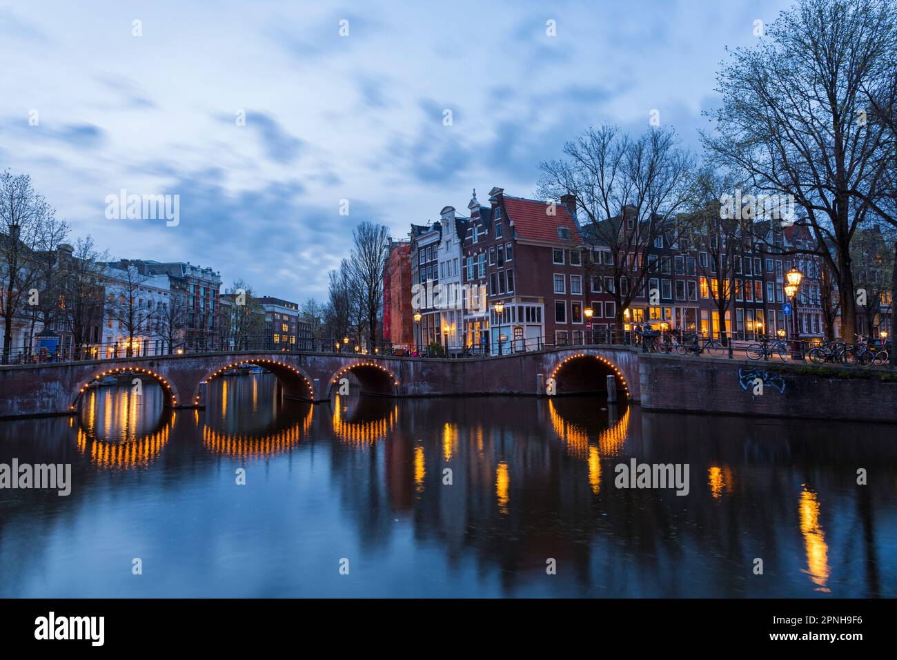 Ponti illuminati al crepuscolo ora blu ad Amsterdam, Olanda, Paesi Bassi nel mese di aprile - lunga esposizione Foto Stock