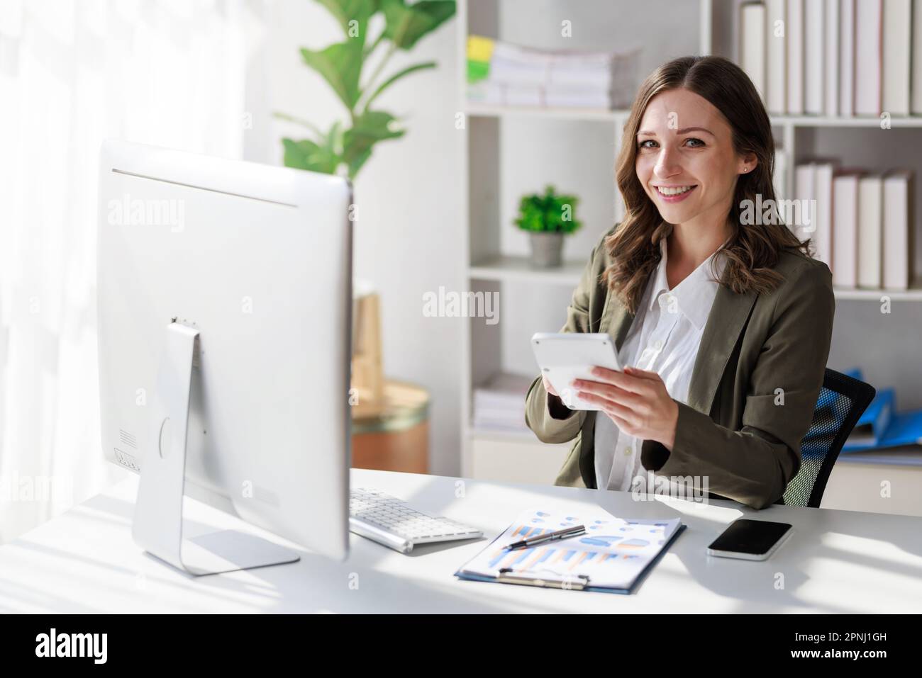 Concetto di investimento di affari o di donna di lavoro, Businesswoman che indossa un vestito seduta e che lavora all'analisi dei documenti di investimento di affari e noi Foto Stock